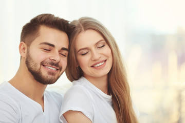 Portrait of young couple on light blurred background