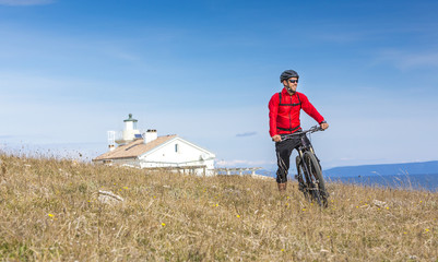 Obraz premium Mountainbiker mit Ebike am Meer