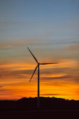 Obraz premium Silhouette of wind turbine on sunset