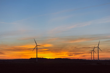 Obraz premium Silhouette of wind turbine on sunset