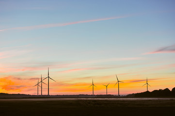 Silhouette of wind turbine on sunset