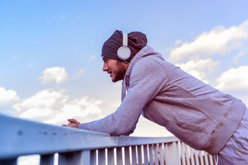 Man runner taking a break after intensive training outdoors, listening music on his mobile smart phone © lordn