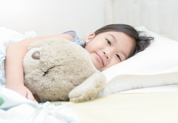 cute little asian girl smile and hug teddy bear