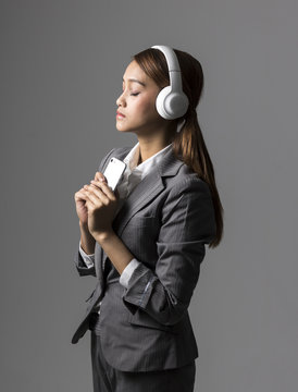 young business woman listening a music with wireless headphones and smart phone