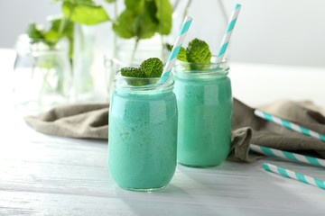 Tasty milk shake cocktail with mint on table