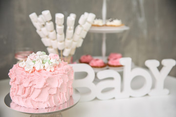 Tasty birthday cake and sweets on table against grunge wall