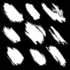 Vector set of white inc splash, blots, smudge and brush strokes, isolated on the black background. Grunge elements for design.