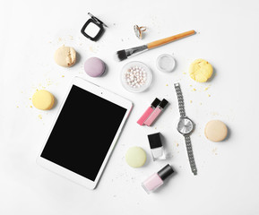 Makeup cosmetic with macaroons and tablet on white background