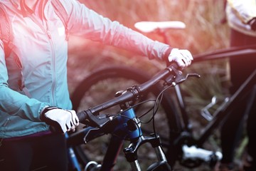 Midsection of female biker with mountain bike