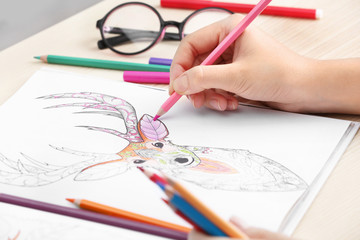 Woman coloring anti stress picture, closeup