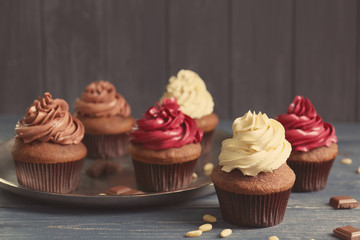 Tasty chocolate cupcakes on wooden table
