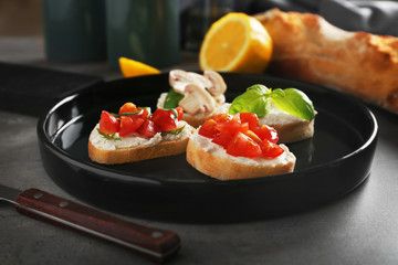 Tasty bruschetta on black plate