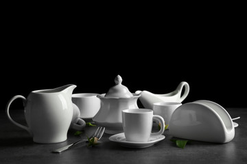 White porcelain tea set on grey table and black background