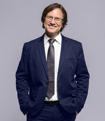 Confident man in suit on grey background