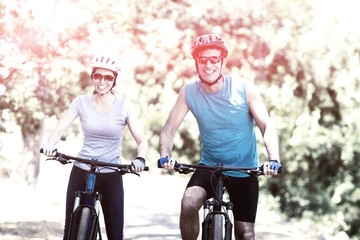Obraz premium Couple smiling and posing with their bikes 