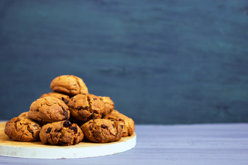 Chocolate cookies on white wooden stand and blue, purple background