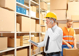 Young businessman with tablet at warehouse