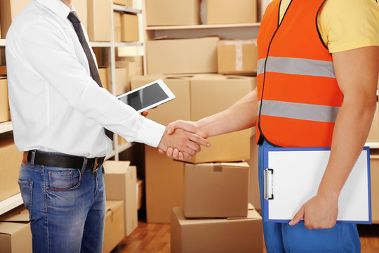 Two businessmen shaking hands at warehouse