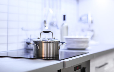 Metallic saucepan in modern kitchen interior