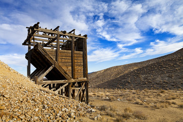 Fototapeta na wymiar Old wooden mine workings in the Nevada desert. Head frames and bins were used to raise and sift materials.