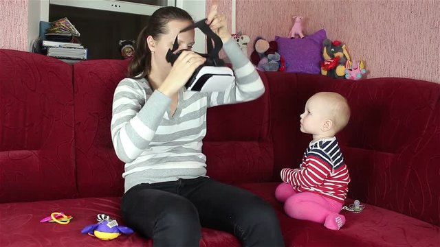 Mom plays with the baby. displays virtual reality mask.