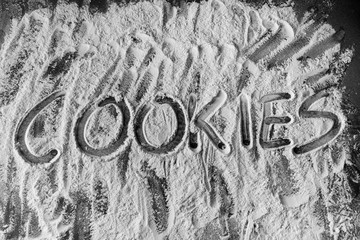 Word cookies written in flour on table