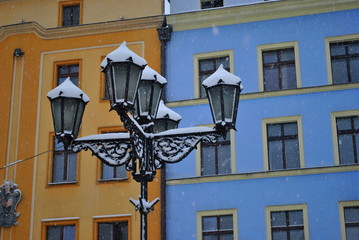 Latarnia uliczna w śniegu na tle kolorowych kamienic © bnorbert3