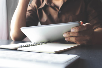 businessman working tablet in office with film colors tone, soft-focus and over light in the background