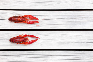 Red steamed crawfish on the white wooden background. Boiled crayfish. Rustic style. Seafood menu. Cover for the magazine.