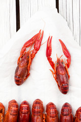 Red steamed crawfish on the white wooden background. Boiled crayfish. Rustic style. Seafood menu. Cover for the magazine.