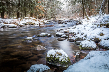 Winter river scene flowing among snowy rocks