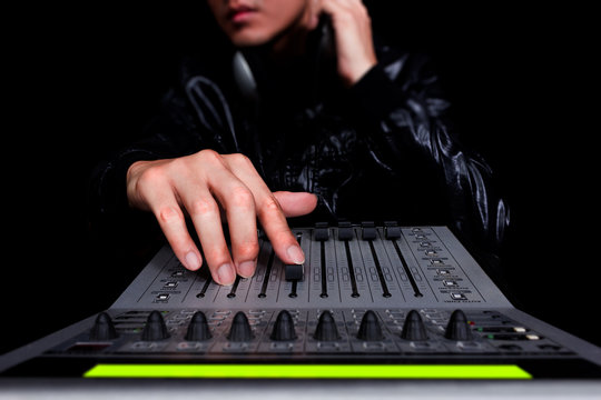 hands of asian handsome DJ, producer working on digital studio mixer for night club, radio, TV broadcasting background