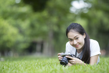 girl with camera lie down on grass