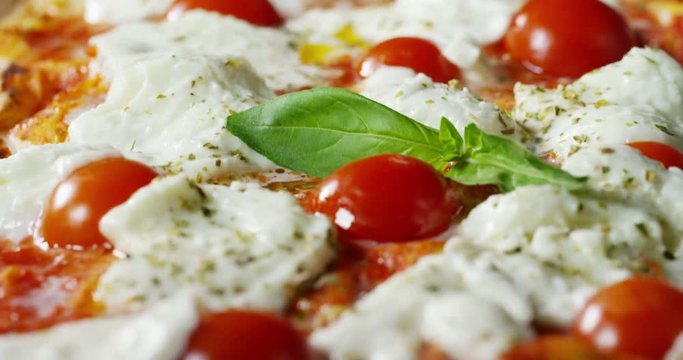 Super slow motion of a middle aged chef cutting mozzarella of bufala cheese for pizza on a restaurant kitchen table in 4k (close up)