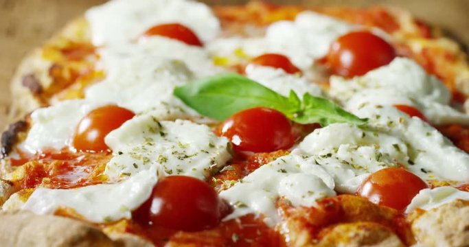 Super slow motion of a middle aged chef cutting mozzarella of bufala cheese for pizza on a restaurant kitchen table in 4k (close up)