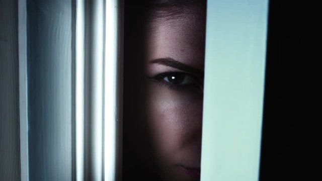 4K Thriller Woman Eye Looking in Door Gap, zoom in