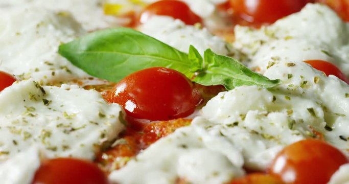 Super slow motion of a middle aged chef cutting mozzarella of bufala cheese for pizza on a restaurant kitchen table in 4k (close up)