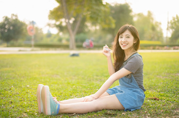 Portrait asian woman smiling happy freedom in park with sunlight
