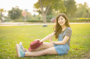 Naklejka na ściany i meble Portrait asian woman smiling happy freedom in park with sunlight