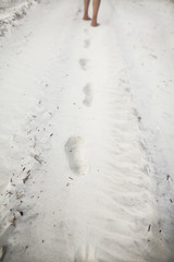 Person leaving footprints in sand at the beach