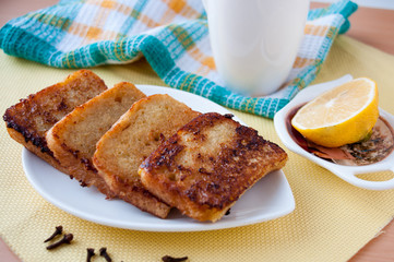 On a white plate of toast and half a lemon next  