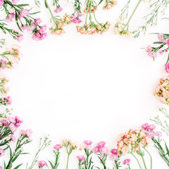 Naklejka na ściany i meble Round frame of colorful wildflowers, green leaves, branches on white background. Flat lay, top view. Valentine's background