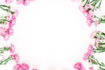 Wreath frame made of pink wildflowers, green leaves, branches on white background. Flat lay, top view. Valentine's background