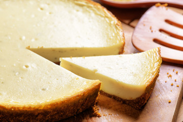 Piece of freshly baked cheesecake on wooden board