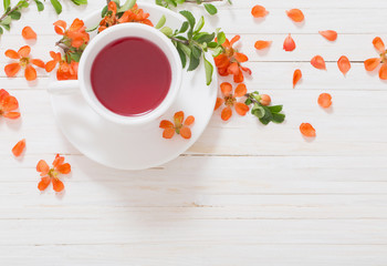 still life with cup of tea and orange flowers