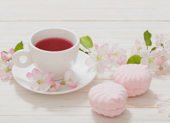 Red tea with flowers on white wooden background