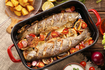 Baked fish with vegetables and potatoes in pan