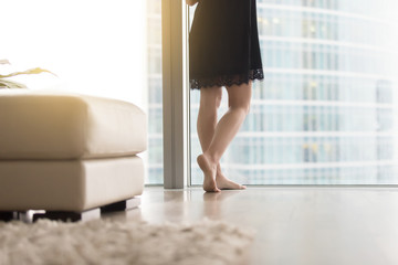 Close up of female bare legs near full length window, relaxing after work day been full of meetings and running around, soft carpet and clean floor, comfortable living space, cleaning service