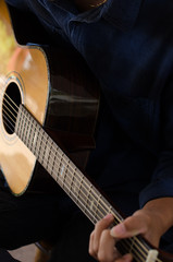 Fototapeta premium A young man playing acoustic guitar happy and relaxed in the day