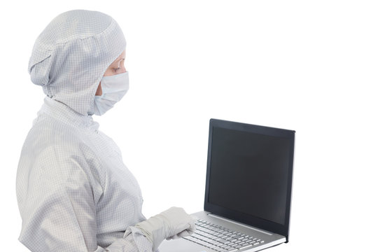 scientist in a suit and mask works with the computer on a white background